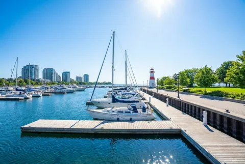 The sunny Port Credit Mississauga marina with sailboats on blue water.